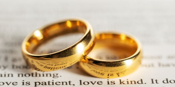Presentamos listado completo de los Aniversarios de Boda por Año con un par de alianzas de oro sobre la frase "El amor es paciente, el amor es amable".